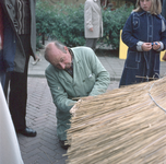 831121 Afbeelding van een rietdekker tijdens een demonstratie oude ambachten op de jaarmarkt in Cothen die werd ...